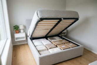 Lit coffre ouvert révélant un rangement intégré organisé dans une petite chambre minimaliste scandinave